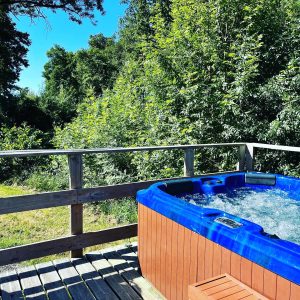 Hébergement insolite en Pays de la Loire avec jacuzzi extérieur entouré de verdure.