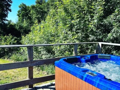 Hébergement insolite en Pays de la Loire avec jacuzzi extérieur entouré de verdure.