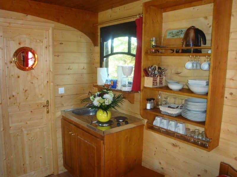 Intérieur chaleureux dun chalet en bois, avec kitchenette et décoration soignée.