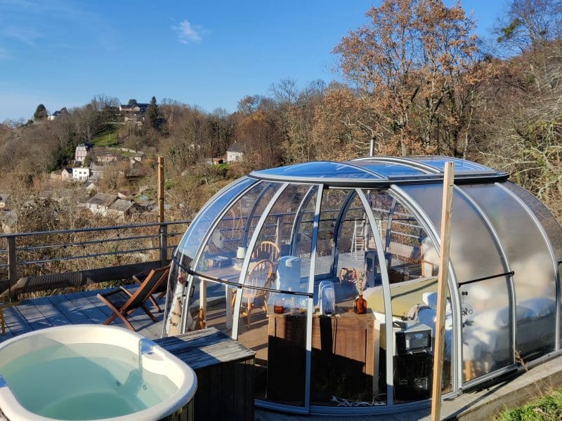Hébergement insolite en bulle transparente avec jacuzzi, vue panoramique sur la nature.