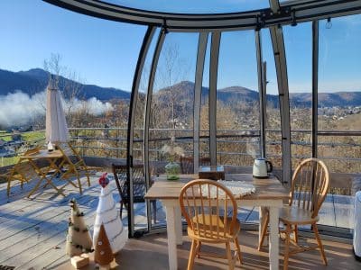 Hébergement insolite en verre avec vue panoramique sur les montagnes et la nature.