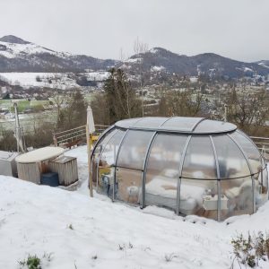Hébergement insolite en bulle transparente, avec vue sur les montagnes enneigées.