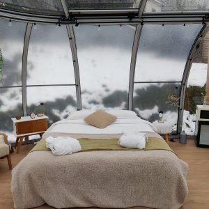 Hébergement insolite en Midi-Pyrénées : chambre moderne avec vue panoramique sur la nature.