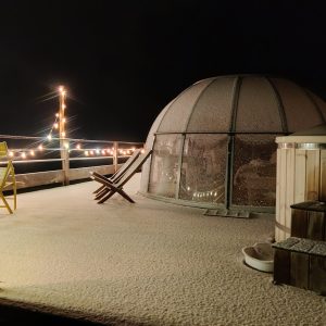 Dôme transparent en Midi-Pyrénées, illuminé, entouré de neige et de confort.