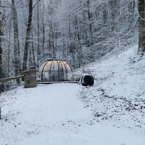 Hébergement insolite en bulle transparente, entouré de neige et darbres en Midi-Pyrénées.