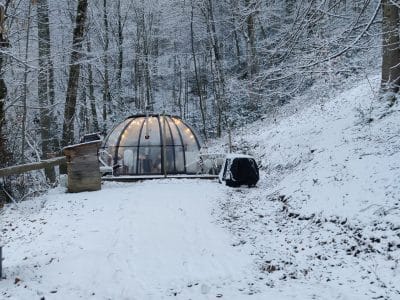 Hébergement insolite en bulle transparente, entouré de neige et darbres en Midi-Pyrénées.