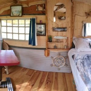 Cabane en bois à Basse-Normandie, avec lit douillet et décor marin chaleureux.