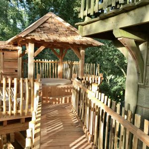 Cabane dans les arbres en Île-de-France, avec un bel espace en bois et un toit en ardoise.