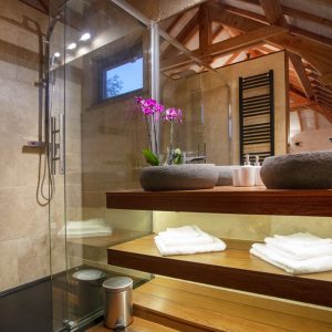 Salle de bain moderne dun hébergement insolite en Languedoc-Roussillon, avec fleurs et bois.