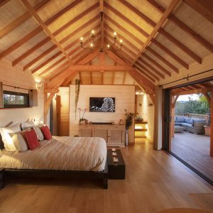 Chalet en bois avec poutres apparentes et vue sur la nature, idéal pour un séjour romantique.