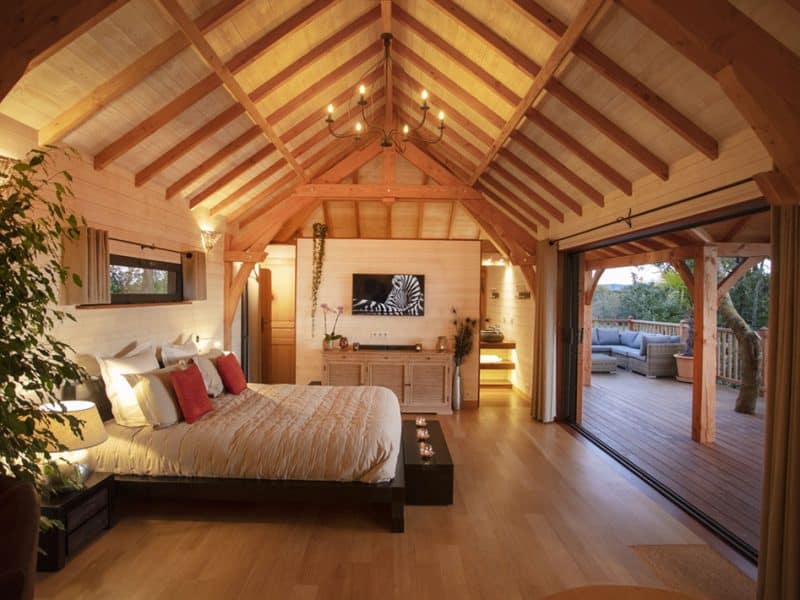 Chalet en bois avec poutres apparentes et vue sur la nature, idéal pour un séjour romantique.