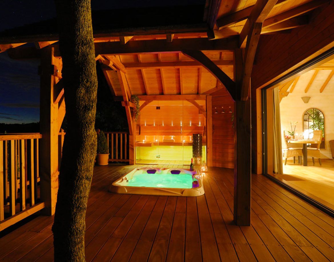 Cabane en bois avec jacuzzi, éclairage doux et vue sur la nature au Languedoc-Roussillon.