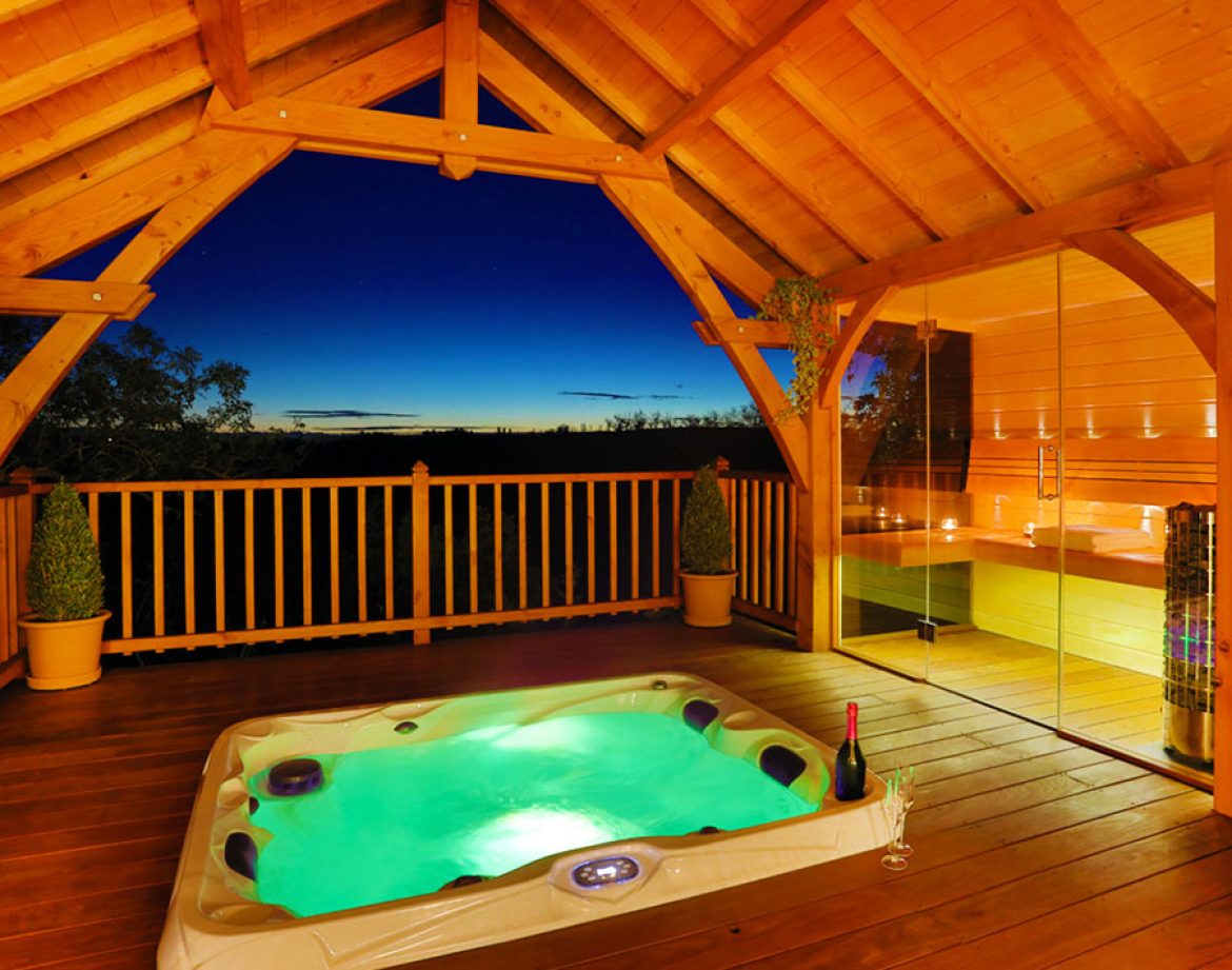 Cabane en bois avec jacuzzi, offrant une vue imprenable sur le coucher de soleil.