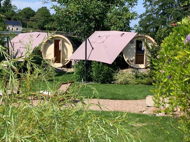 Hébergement insolite en Bourgogne : cabanes rondes avec toits en toile, entourées de verdure.