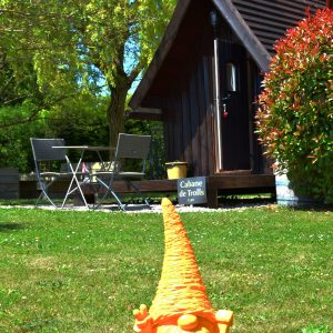 Cabane de trolls en Nouvelle-Aquitaine, avec un gnome orange et une terrasse accueillante.