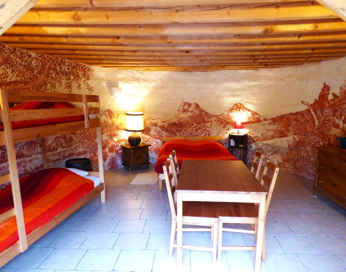 Hébergement insolite en Auvergne : chambre avec lits superposés et murs décorés.