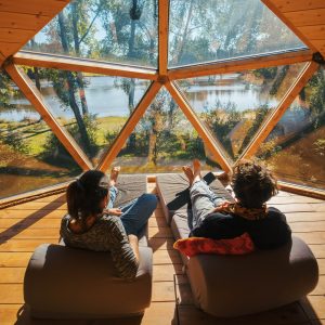 Dôme géodésique en Auvergne, avec vue panoramique sur un lac et la nature environnante.
