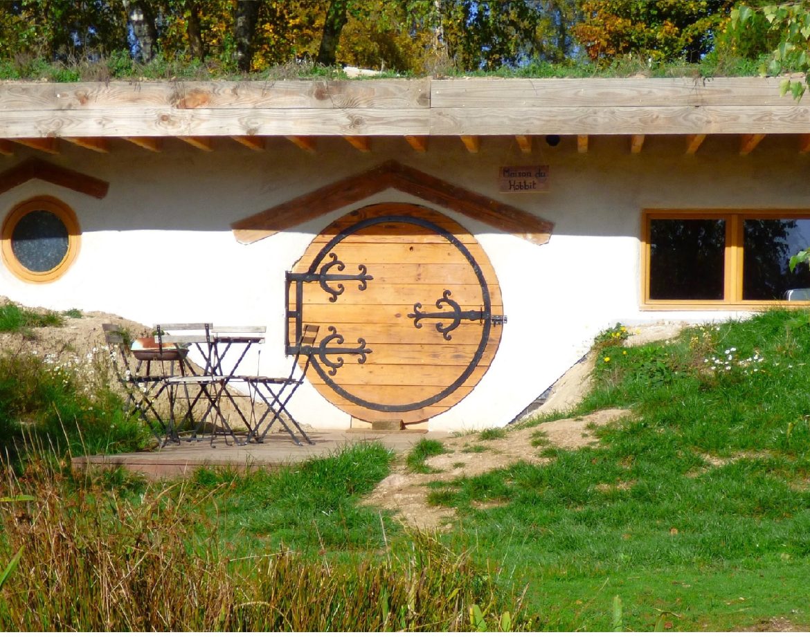 Hébergement insolite en Auvergne : charmante maison ronde avec porte en bois et terrasse.
