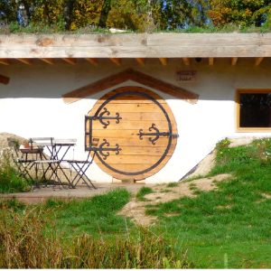Hébergement insolite en Auvergne : charmante maison ronde avec porte en bois et terrasse.