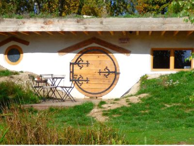 Hébergement insolite en Auvergne : charmante maison ronde avec porte en bois et terrasse.
