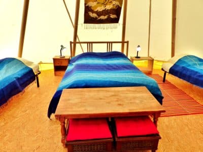 Tente glamping en Auvergne, avec lits confortables et décor coloré.