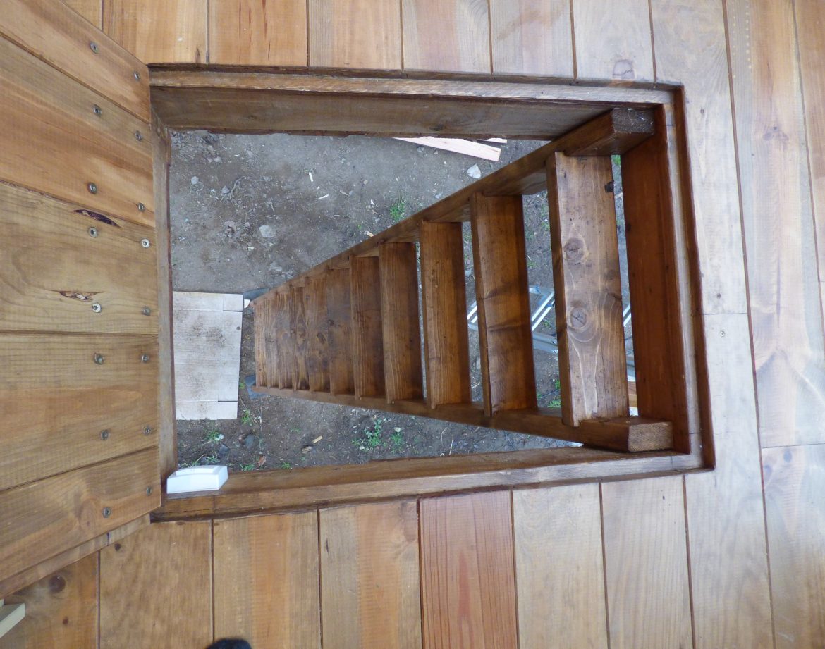Escalier en bois menant à un hébergement insolite en Auvergne, ambiance naturelle.