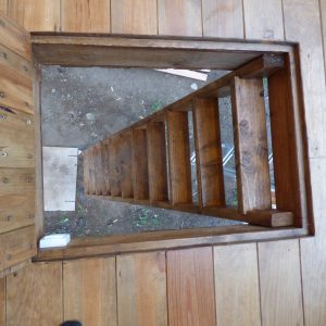 Escalier en bois menant à un hébergement insolite en Auvergne, ambiance naturelle.
