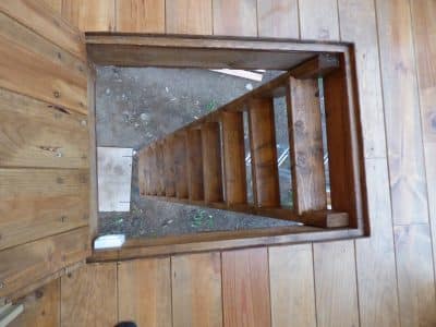 Escalier en bois menant à un hébergement insolite en Auvergne, ambiance naturelle.