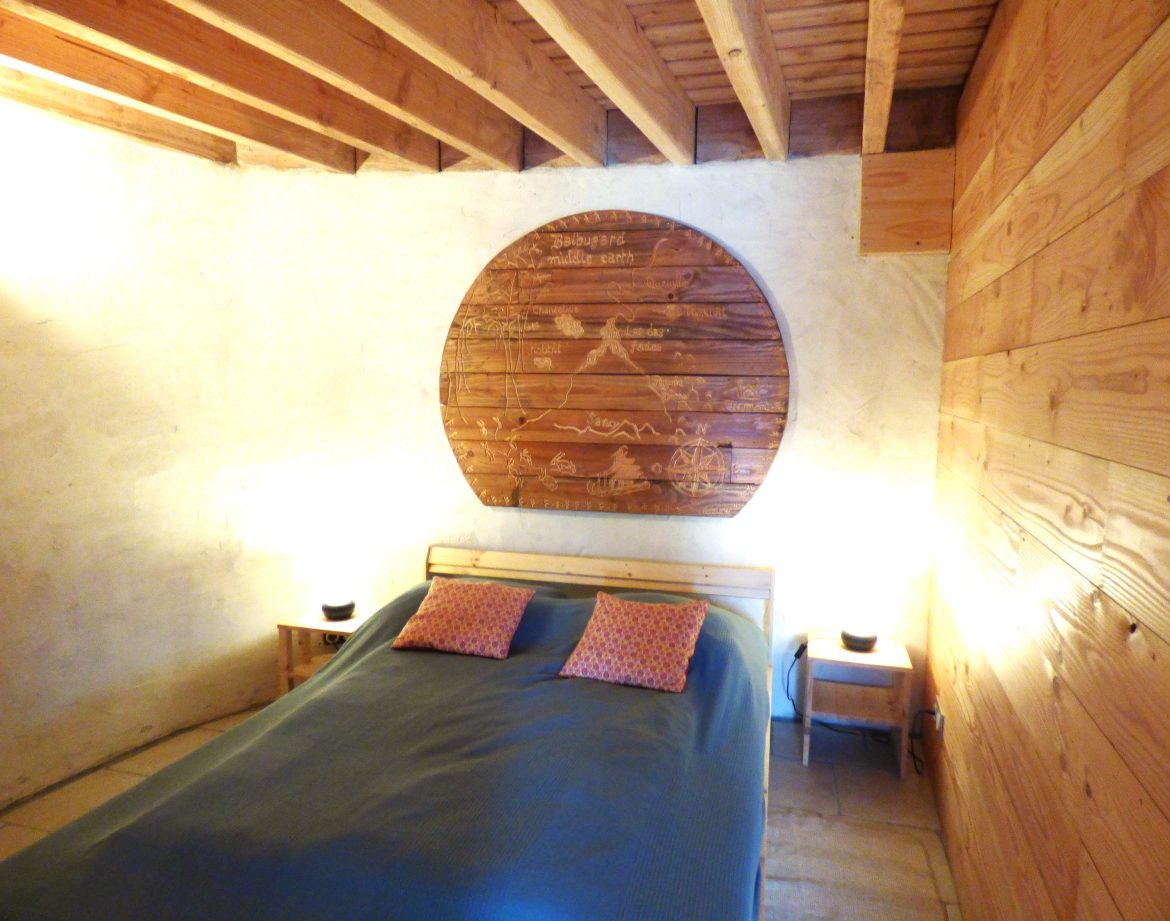 Chambre dhôte en bois avec un grand panneau décoratif et éclairage chaleureux.