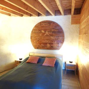 Chambre dhôte en bois avec un grand panneau décoratif et éclairage chaleureux.
