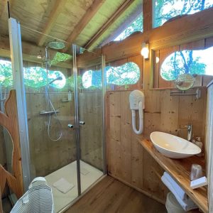 Salle de bain en bois dans un hébergement insolite en Hauts-de-France, lumineux et moderne.