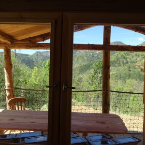 Cabane en bois avec vue panoramique sur les montagnes verdoyantes.