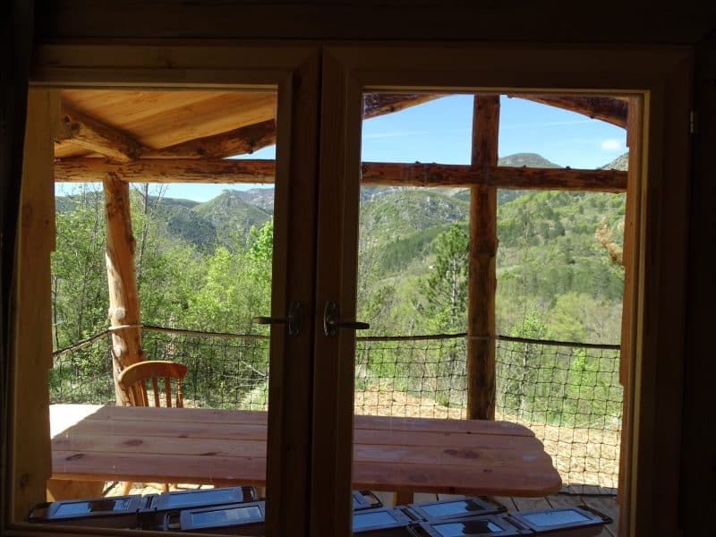 Cabane en bois avec vue panoramique sur les montagnes verdoyantes.
