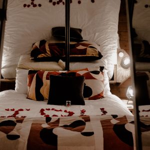 Chambre romantique dans un hébergement insolite, décorée de pétales de roses.