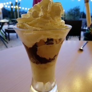 Dégustation dune coupe glacée crémeuse sous les guirlandes lumineuses en Languedoc-Roussillon.