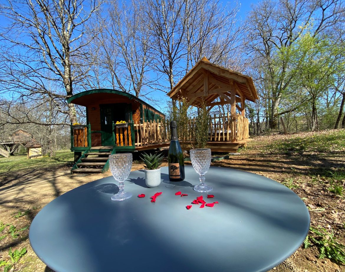 Roulotte romantique en Aquitaine, avec un gazebo et des pétales de rose sur la table.