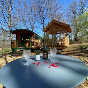 Roulotte romantique en Aquitaine, avec un gazebo et des pétales de rose sur la table.
