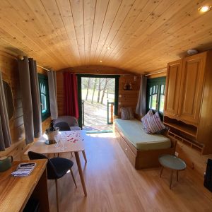 Intérieur chaleureux dune roulotte en Aquitaine, avec un coin salon lumineux.