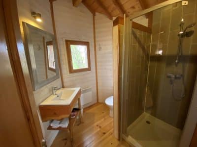Salle de bain moderne en bois dans un hébergement insolite en Aquitaine.