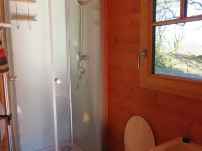 Cabane en bois en Bretagne avec douche moderne et vue sur la nature.