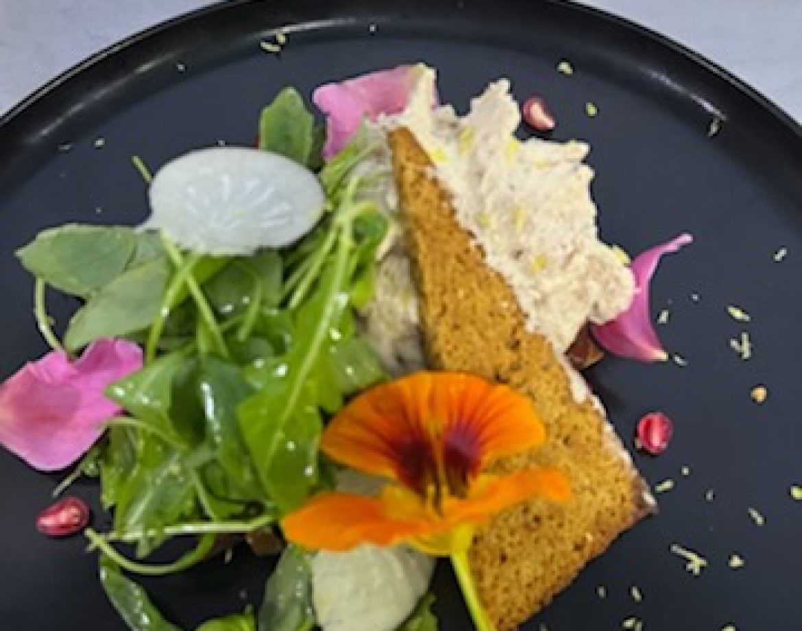 Plat gourmet avec salade fraîche et fleur comestible, dans un hébergement insolite.