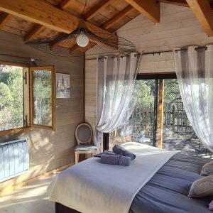 Cabane en bois en Corse, avec de grandes fenêtres et une vue sur la nature.
