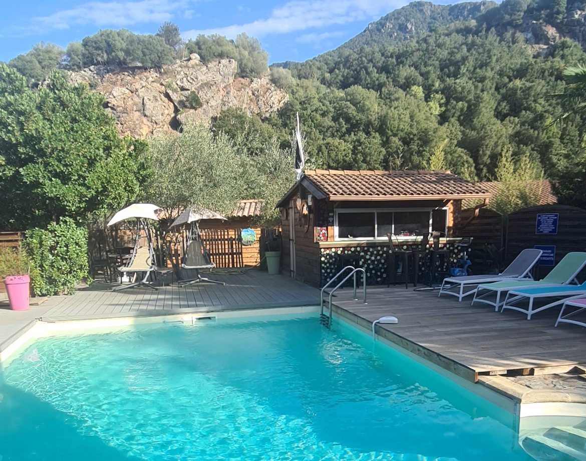Hébergement insolite en Corse avec piscine et vue sur les montagnes verdoyantes.
