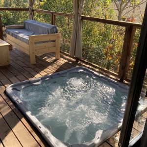 Cabane perchée en Languedoc-Roussillon avec jacuzzi sur la terrasse en bois.