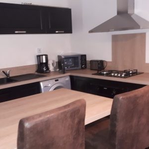 Cuisine moderne dun hébergement insolite en Grand-Est, avec table et chaises confortables.