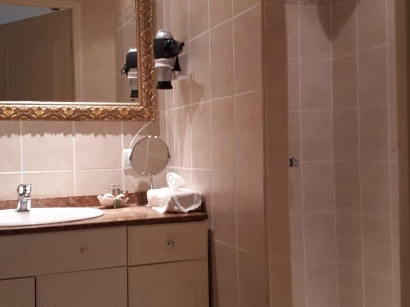 Salle de bain élégante dun hébergement insolite en Grand-Est, avec miroir doré.