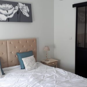 Chambre dhôtes moderne avec lit douillet et décoration florale apaisante.