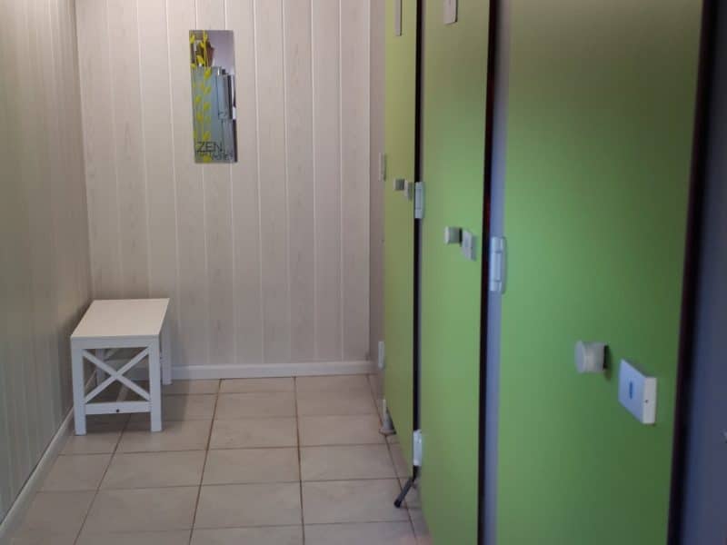 Chalet moderne avec portes vertes, offrant un espace accueillant et lumineux.
