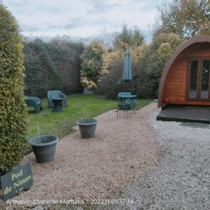 Pod en bois à Ninon, jardin verdoyant avec mobilier extérieur et parasol.