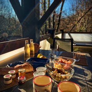 Hébergement insolite en Midi-Pyrénées, terrasse en bois avec petit-déjeuner gourmand.